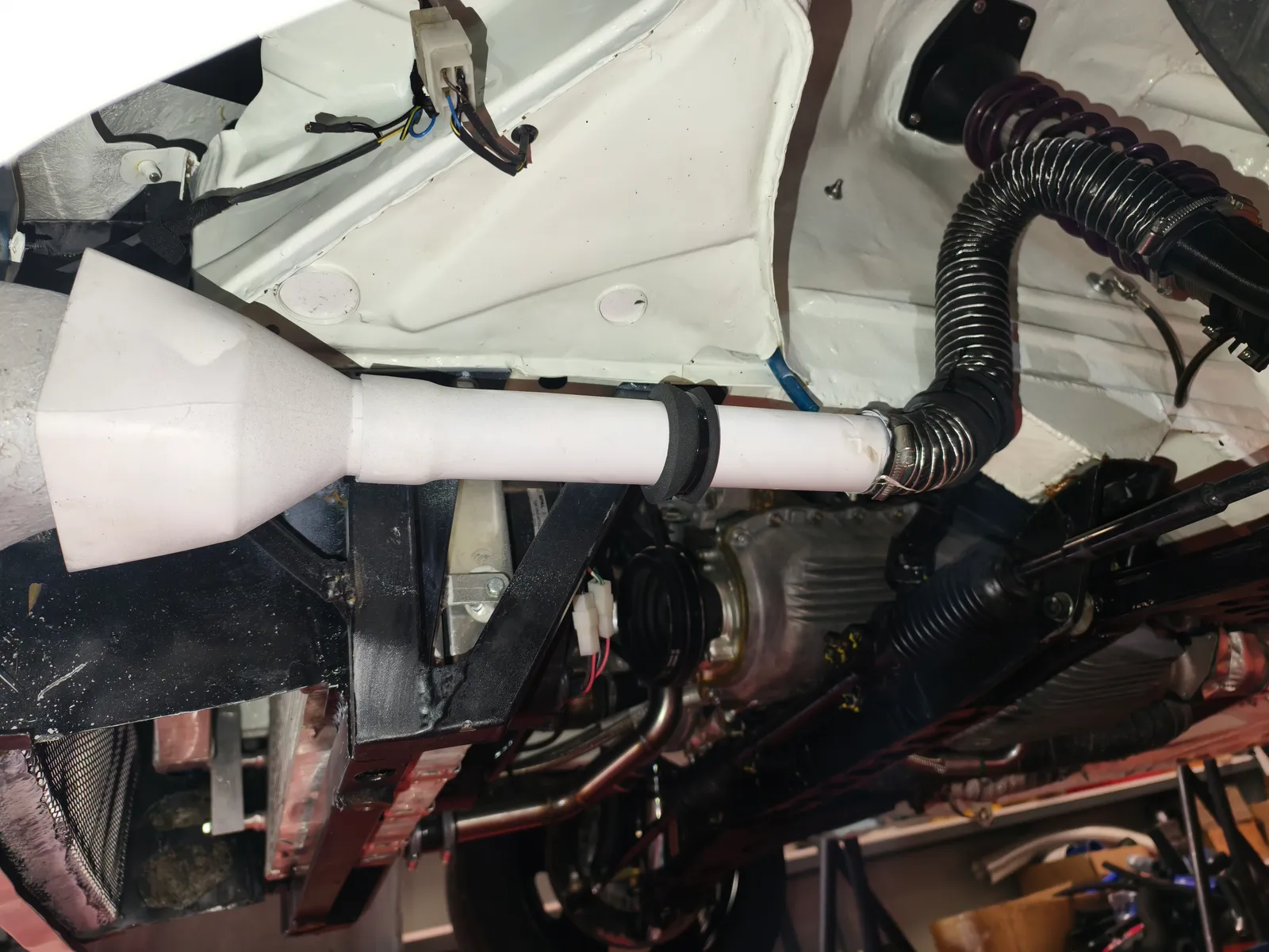 Reductor impreso en 3D tras la boca del antiniebla del Porsche 924, con tubo flexible acoplado