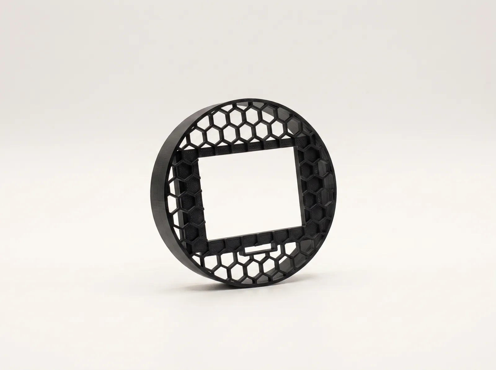 Soporte de pantalla OBD2 para Seat Ibiza 6L sobre fondo claro: disco de celosía hexagonal con la ventana rectangular de la pantalla