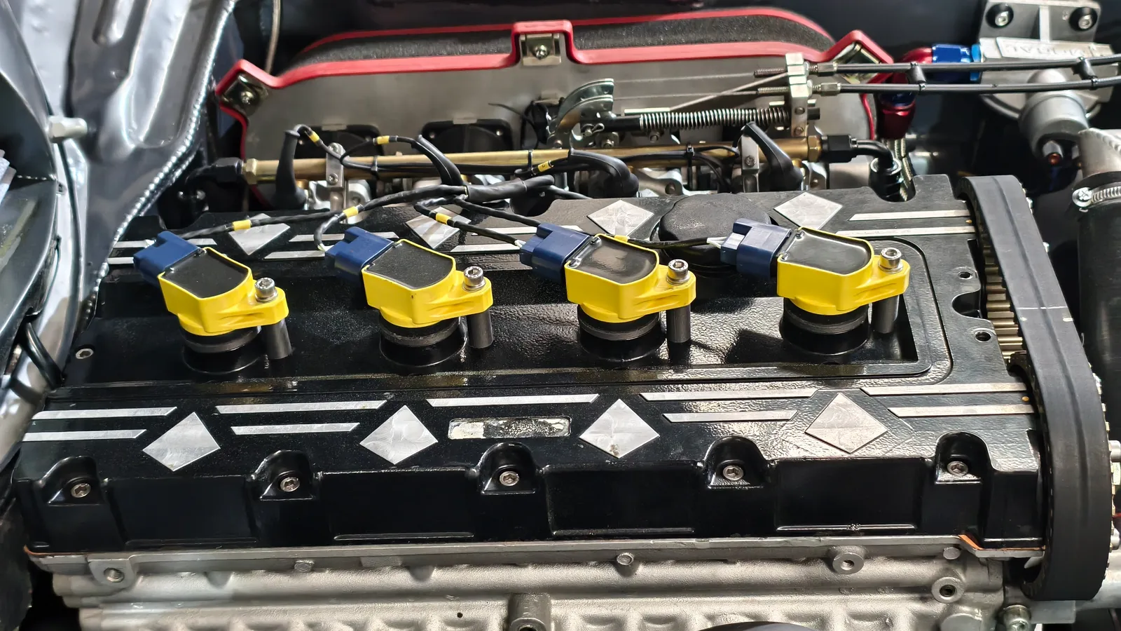 Cuatro bobinas individuales sobre soportes impresos en 3D en la tapa del motor Ford